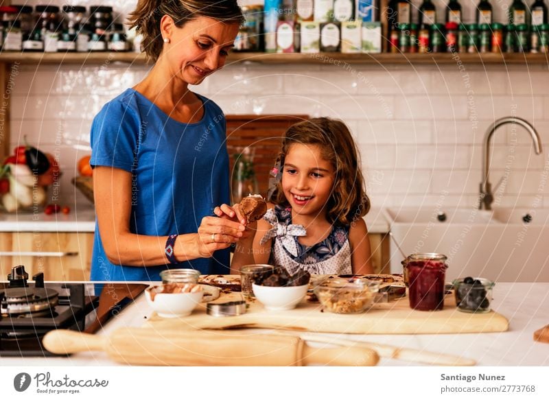 Little girl cooking with her mother in the kitchen. Mother Girl Cooking Kitchen Chocolate Ice cream Daughter Day Happy Joy Family & Relations Love Baking Food