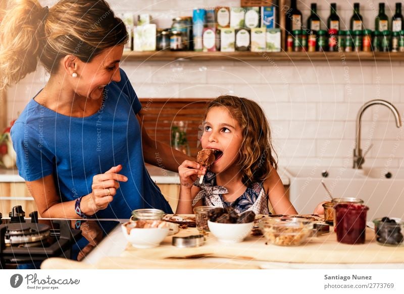 Little girl cooking with her mother in the kitchen Mother Girl Cooking Kitchen Chocolate Ice cream Daughter Day Happy Joy Family & Relations Love Baking Food