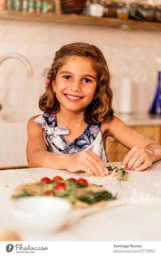 Portrait of little girl preparing baking cookies. Girl Child Nutrition To feed savoring Eating enjoying Flour Dough Portrait photograph Appetite Smiling