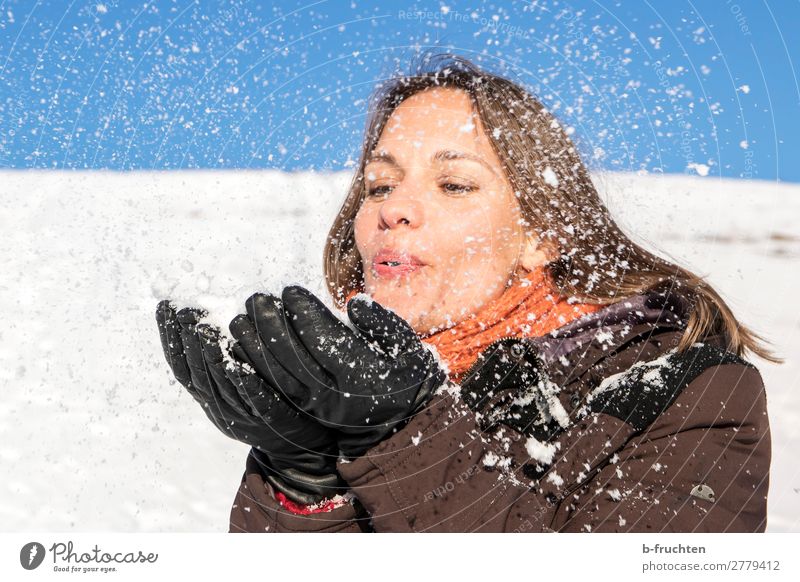 Woman blowing snow from her hands Adults Face Hand Fingers 1 Human being Winter Snow Coat Scarf Happiness Joy Contentment Joie de vivre (Vitality) Sympathy
