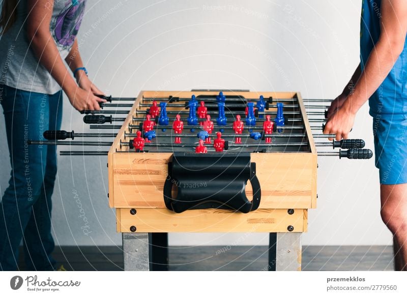 Young teenager boy playing table football with another player. Lifestyle Joy Relaxation Leisure and hobbies Playing Summer Table Sports Soccer Boy (child) Man