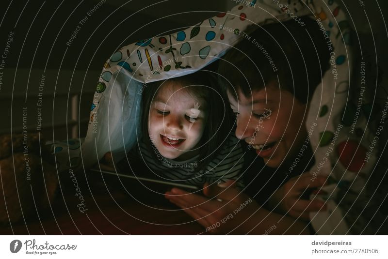 Brothers looking at the tablet in the dark Joy Happy Face Playing Bedroom Child Technology Internet Human being Boy (child) Woman Adults Man Sister