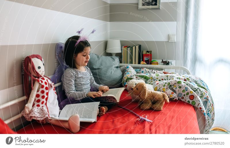 Little girl sitting on bed reading book to her toys Joy Beautiful Playing Reading Bedroom Child Teacher To talk Human being Woman Adults Friendship Book