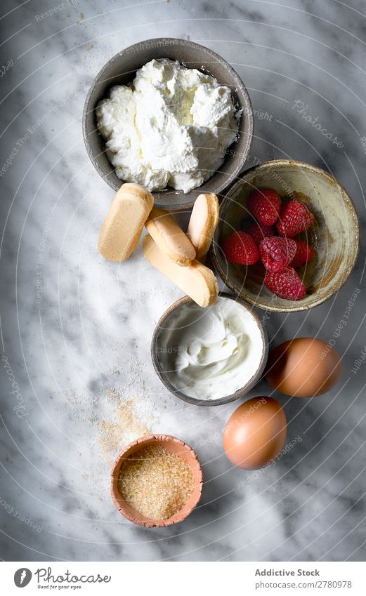 Top view of cake ingredients on table Ingredients Cake Fresh products biscuits Raspberry Cream Conceptual design Egg Sugar composition Marble Arrangement Food