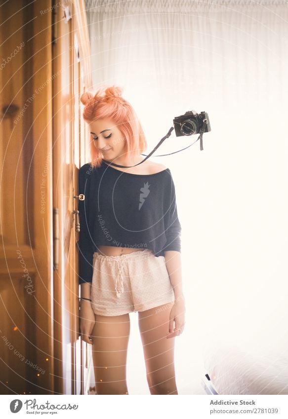 Film camera flying beside young pink-haired woman Camera Woman Portrait photograph Flying levitate Vintage pink hair Attractive beauitful Strange