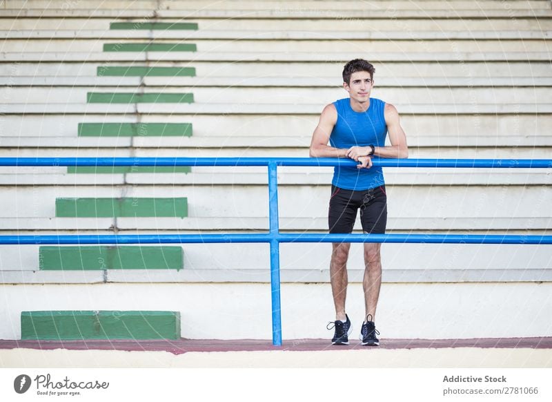 Sportsman posing on stadium Man Stadium Athletic Posture Rest sportsman Fitness Contentment Practice Lean Athlete Muscular Relaxation Adults Sprinter Fence