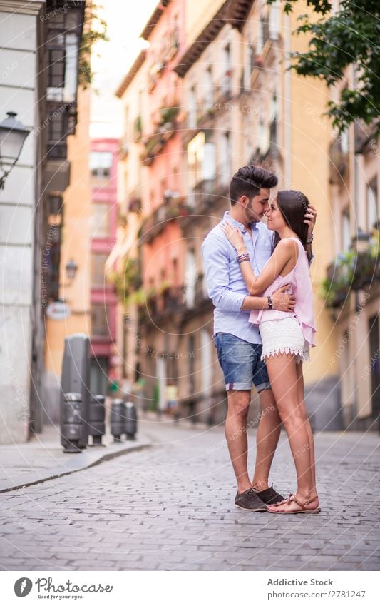 Romantic couple hugging on road against buildings Couple Street Profile Kissing Point in time Romance Face to face Building Facade Background picture Easygoing