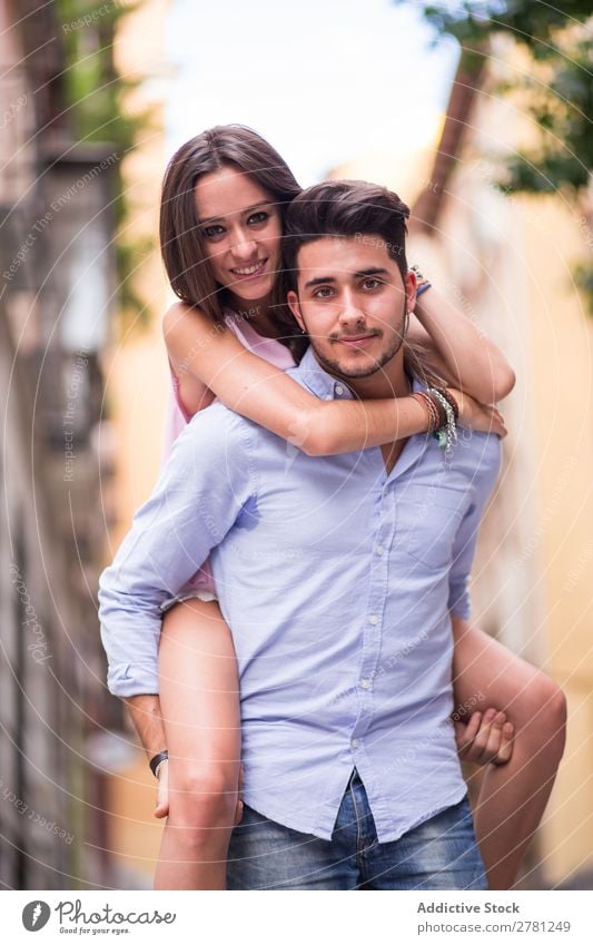 Beautiful couple having fun and smiling at camera Couple piggy back Portrait photograph Looking into the camera handsome Beard Embrace Blur Background picture