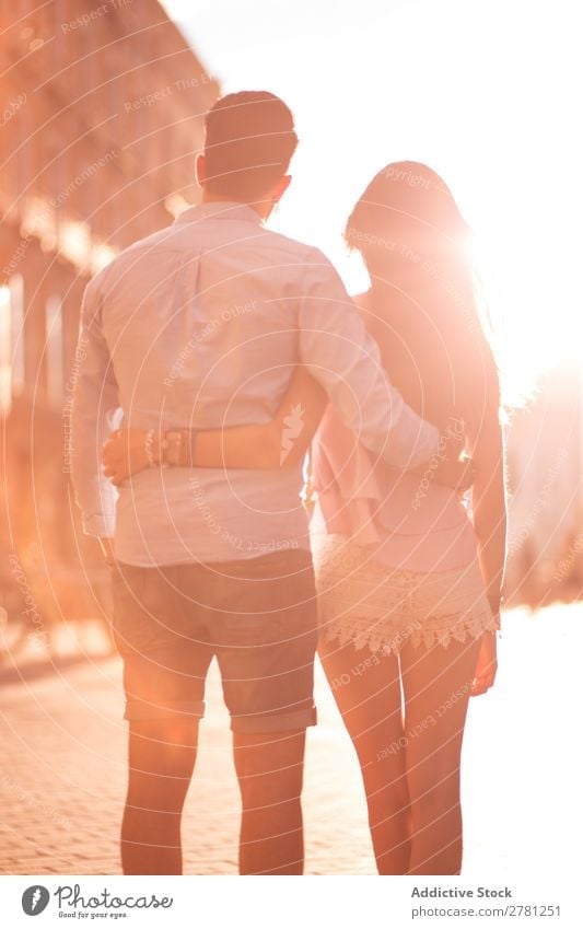 Unrecognizable hugging couple in sunny street Couple Embrace Street Rear view Sunlight Bright Walking Stand Observe Vertical Stern Blur Sunbeam Brunette