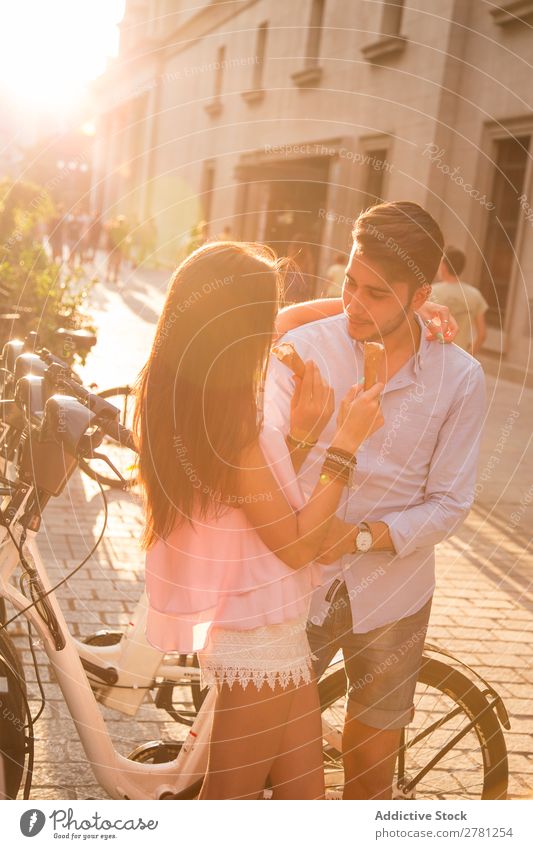 Couple sharing ice cream in the street Eating Ice cream Street Food Share Tasty Dessert Face to face Embrace Sunlight Bright backlit Summer Easygoing Stand