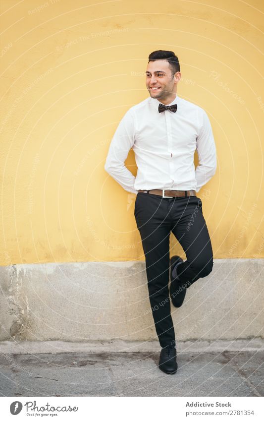 Happy Welldressed Businessman Leaning On Yellow Wall 20s Adults Architecture Away Back Behind Bow tie Businesspeople Businessperson Caucasian Self-confident