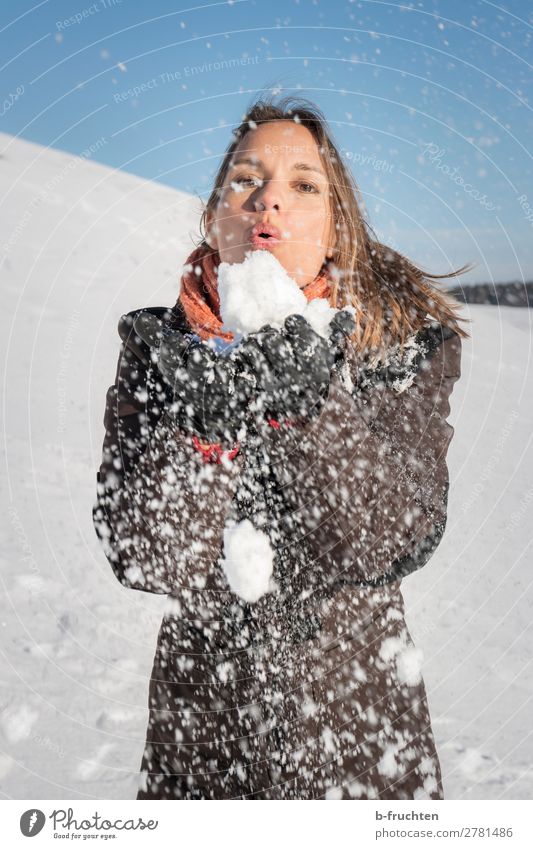 Woman blowing snow from her hands Adults Face Hand 1 Human being Sky Winter Snow Utilize Touch To hold on Brash Exterior shot Blow Snowflake Distribute Hill