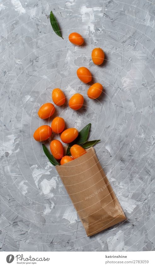 Kumquat fruits on a grey background Fruit Dessert Nutrition Vegetarian diet Diet Exotic Group Leaf Paper Fresh Natural Above Juicy Yellow Gray Colour citrus