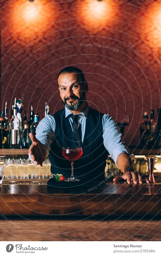 Barman is making cocktail at night club. Cocktail shaker barman bartender Waiter Man Portrait photograph portraiture Stir mixologist adding Alcoholic drinks