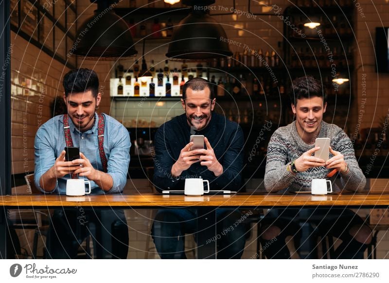 Friends using mobile and laptop. Man Coffee Friendship Youth (Young adults) Teamwork Group Human being Lifestyle PDA Cellphone Mobile Communication Text
