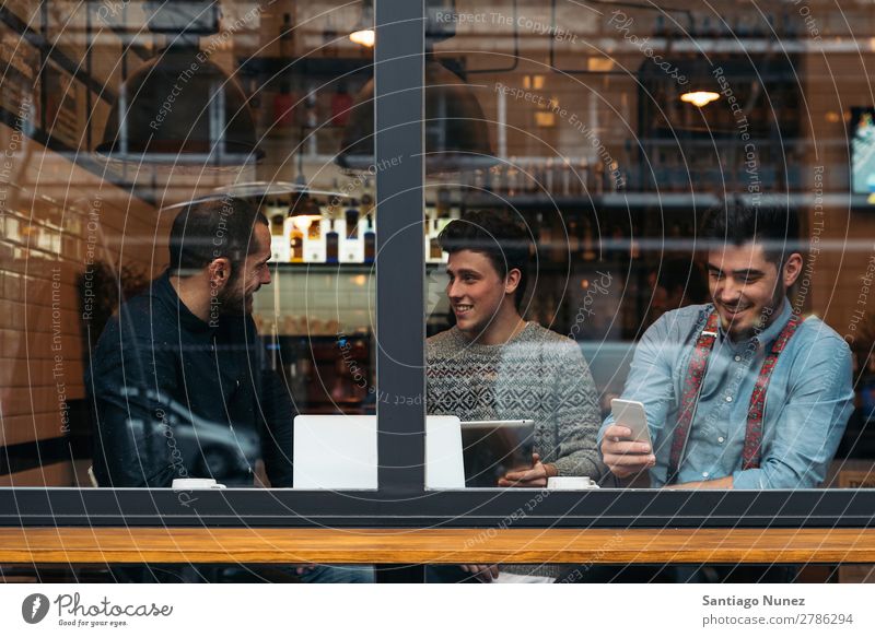 Friends drinking coffee and chatting. Man Coffee Friendship Youth (Young adults) Teamwork Group Human being Lifestyle PDA Cellphone Mobile Communication using