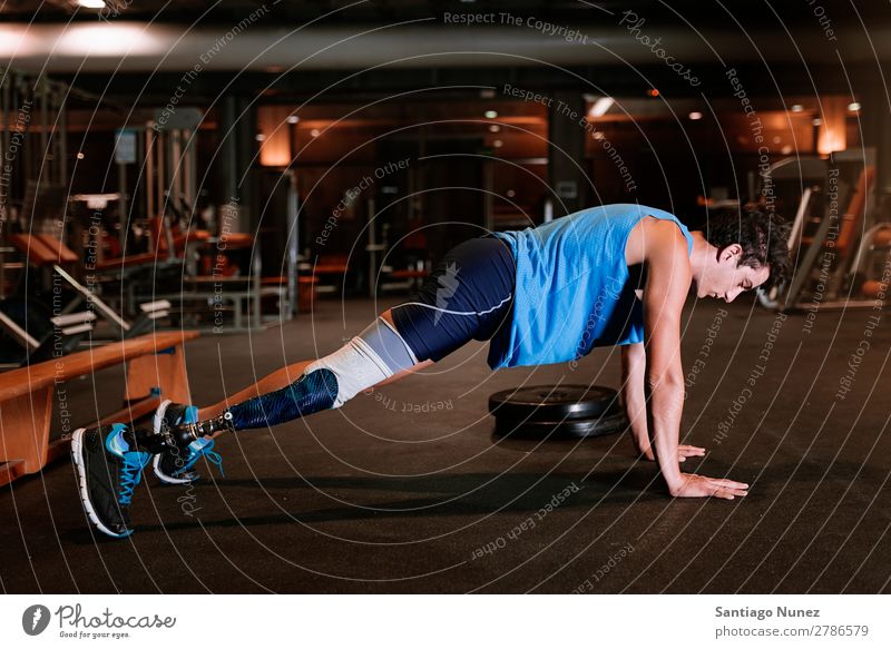 Disabled young man training in the gym. Man Youth (Young adults) Athlete Sports prothestic Handicapped disabled push up Fitness Gymnasium Action Legs amputate