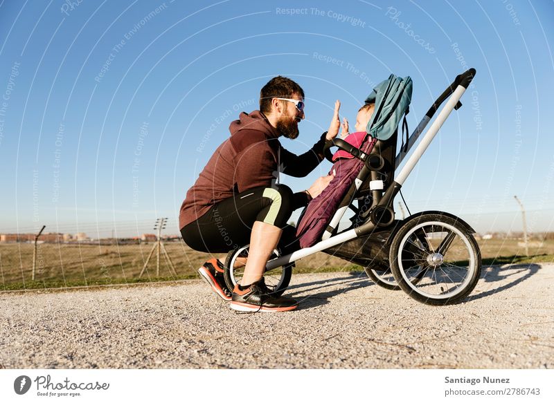 Father and son walking in the park stroller jogging running buggy family baby education smile play child young father outside beautiful exercising nature autumn