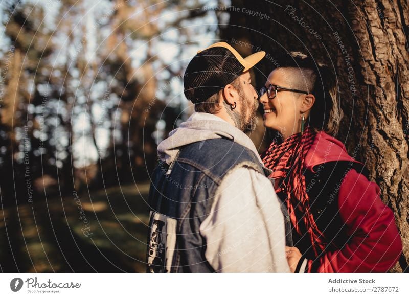 Happy couple hugging near tree in park Couple Embrace Park Tree embracing Back Wood Forest Youth (Young adults) Cheerful bearded Man Woman Joy Hipster Walking