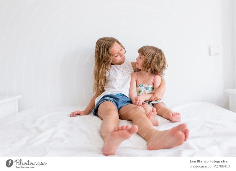 Two beautiful sisters playing on bed Lifestyle Joy Beautiful Leisure and hobbies Playing Summer House (Residential Structure) Bed Bedroom Child Human being