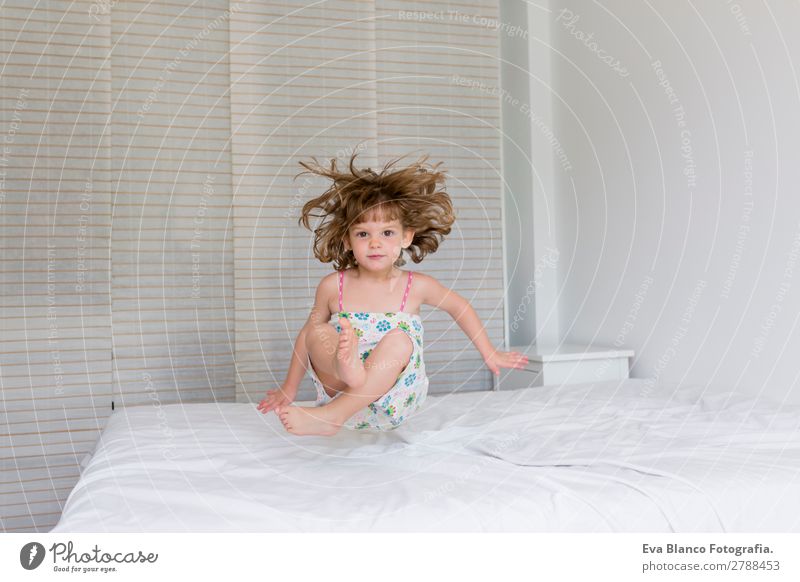 beautiful kid girl jumping on bed Lifestyle Joy Happy Beautiful Leisure and hobbies Playing Reading Summer Bedroom Child Human being Mother Adults Father Sister