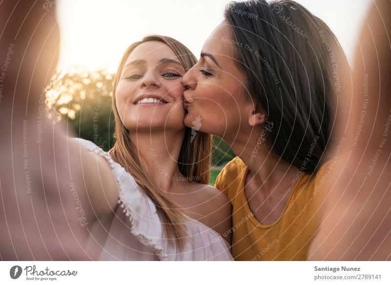 Beautiful women having fun in the park. Woman Friendship Youth (Young adults) Kissing Park Happy Summer Human being Joy Photography Selfie Self portrait Take
