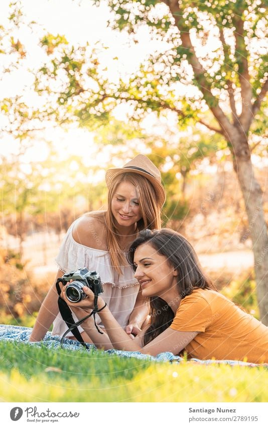 Photographer showing a picture to her friend. Woman Picnic Friendship Youth (Young adults) Park Happy Camera Guitar Guitarist session Photography Indicate