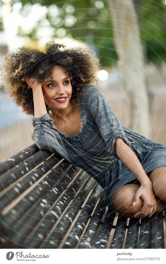 Funny black woman with afro hairstyle sitting on a bench in urban background. Lifestyle Style Happy Beautiful Hair and hairstyles Face Human being Feminine
