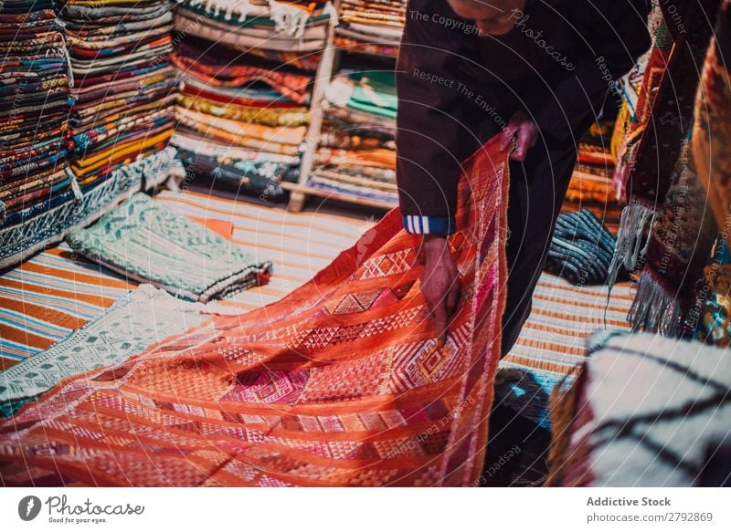 Seller showing carpet in market seller Carpet Indicate Gift Red choice Pick Markets East Bazaar Tradition Shopping Storage Tourism Multicoloured Chechaouen