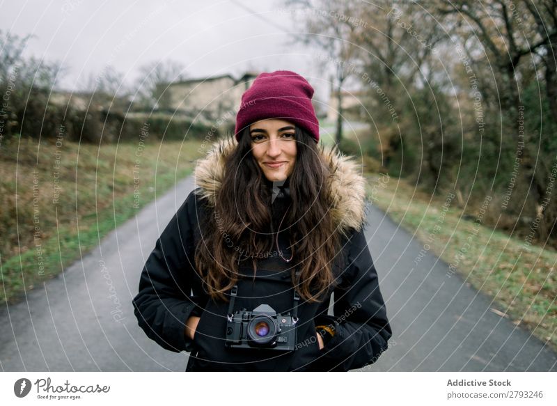 Smiling woman in coat with camera Woman Camera Landscape Coat orduna Spain Lady Hat Hand pocket Cheerful Wear Winter Attractive Youth (Young adults) Street
