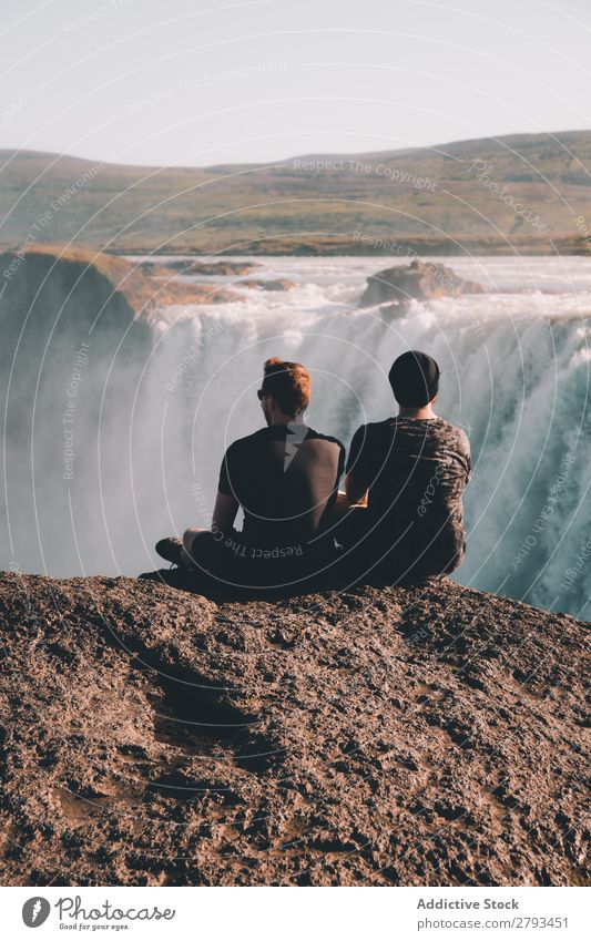 Anonymous men looking at waterfall Man Waterfall Cliff admiring Vantage point Nature Landscape The Arctic Sit Together Vacation & Travel Tourism Trip Adventure