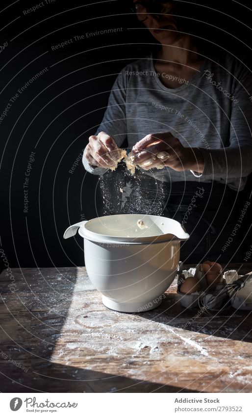 Person cracking egg in bowl on table Egg Bowl Cooking Table Flour Wood Meal Craft (trade) To break (something) Tasty Human being Bread Baked goods Cake Bakery