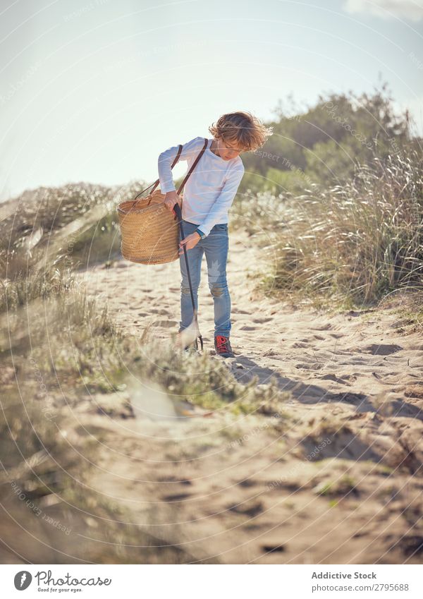 Boy with basket picking up garbage from ground Trash container Ground Child Basket litter picker Boy (child) Container cleaning up Field Shoulder Environment