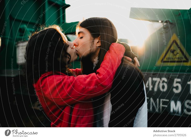 Long haired man hugging and kissing woman near train Couple abandoned wagons Embrace Railroad Graffiti old train Kissing Love Engines Hipster