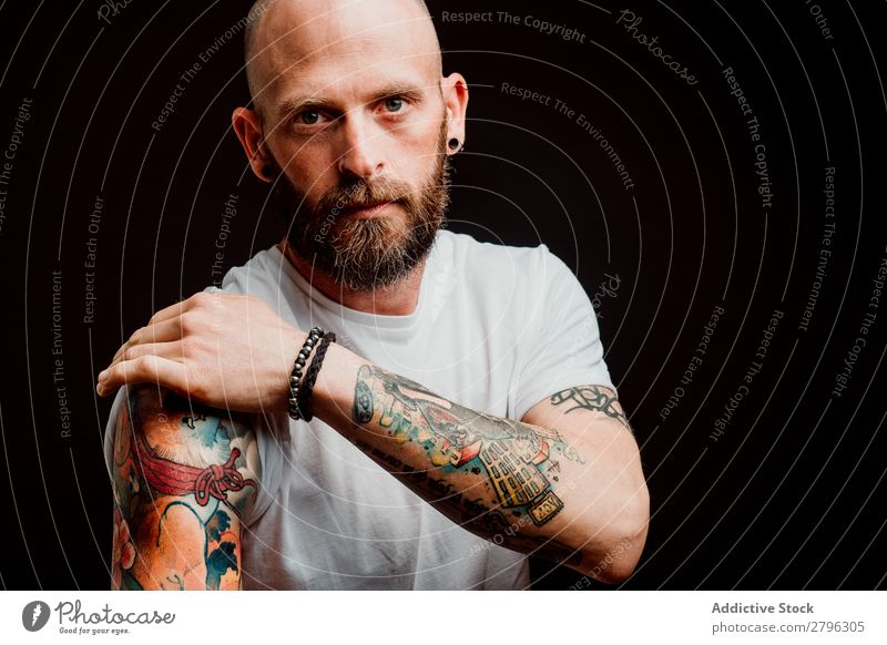 Young bald guy showing tattoos - a Royalty Free Stock Photo from Photocase