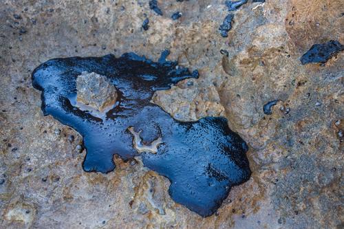Crude oil spill on a rock from the beach Beach Industry Environment Sand Rock Coast Stone Oil Dirty Black Death Disaster Energy Environmental pollution blob