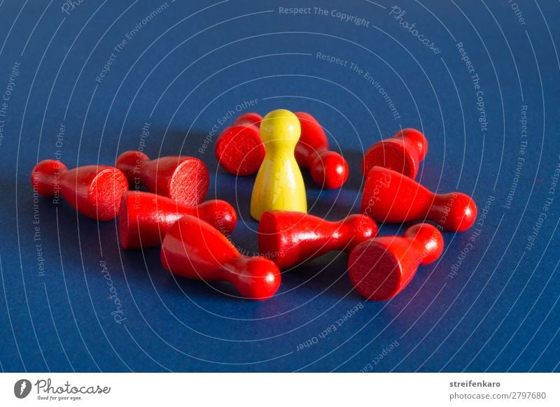 A yellow playing piece stands in the middle of many red lying playing pieces on a blue background Economy Group Toys Wood To talk To fall Fight Lie Stand
