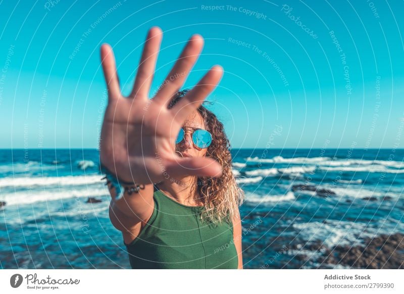 Woman gesturing stop near sea Stop Gesture Ocean Coast Lifestyle Leisure and hobbies Rest Relaxation Waves Sunbeam Palm of the hand Day Refuse Water Style