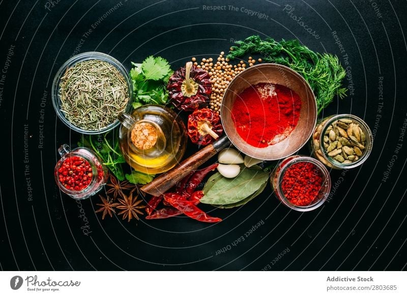 Assorted spices near fresh oil Herbs and spices Oil assortment Cooking Ingredients Set Fresh Dill Parsley Garlic anise Cardamom Coriander Chili pink pepper