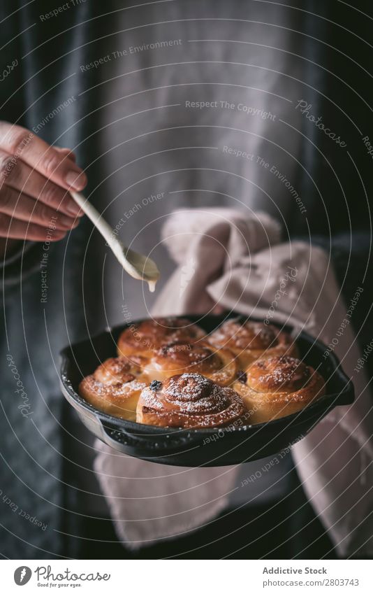 Crop woman adding sauce to cinnamon rolls Woman Sauce Roll Spoon Pan Food Meal Fresh Rustic Gourmet Tradition Dish Cooking Baked goods Delicious Tasty yummy