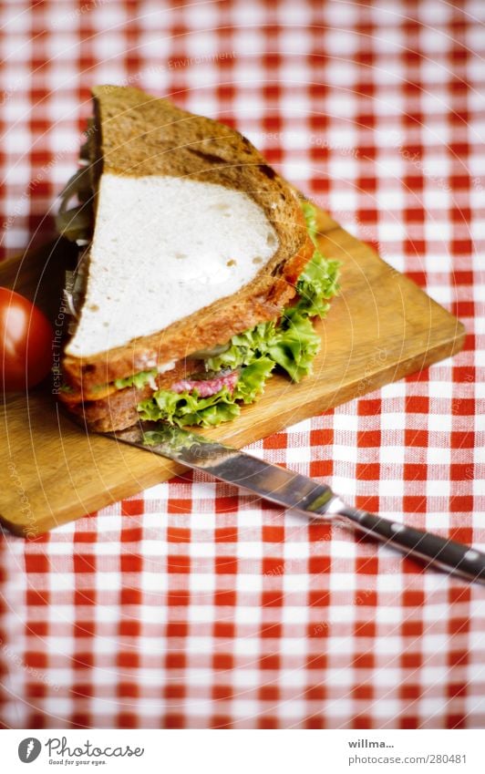 Sandwich of brown bread and white bread, topped with salami and lettuce sandwich White bread Black bread Salami Lettuce Tomato Salad Knives Chopping board