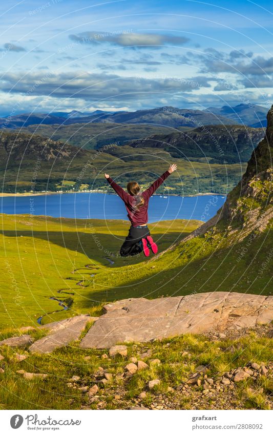 Young Pretty Girl Jumps Happily From Rock In Front Of Spectacular Landscape Of Applecross Pass In Scotland adventure applecross canyon celebrate celebration