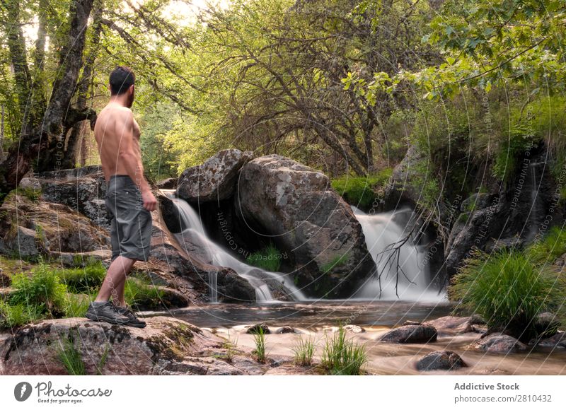 Young man enjoys rest at the waterfall Water Nature Summer Vacation & Travel Man enjoying Waterfall Healthy Body Conceptual design Green Fresh handsome