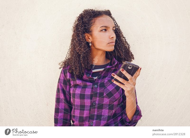 Young casual woman using her smartphone youth cool wifi internet technology call message communication young teen black african afro american diversity