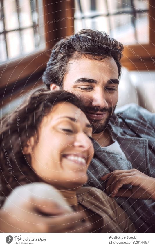 Young couple on the sofa in love Couch Sofa Home Love Relaxation Smiling Interior design Safety (feeling of) Considerate Living room Sit Happiness embracing