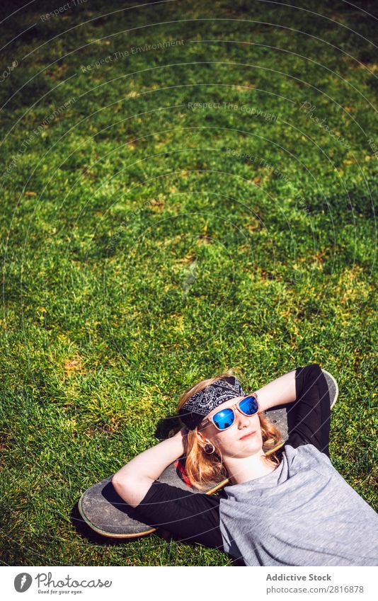 Young woman resting in the grass after practicing skateboard chill Girl Hipster Skateboard Youth (Young adults) Park Light Rest Lie (Untruth) Woman Relaxation