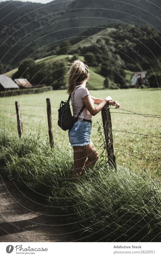 Woman standing at rural fence Field Fence Youth (Young adults) Beautiful Nature Girl Portrait photograph Green Stand Vacation & Travel Lifestyle Backpack Meadow
