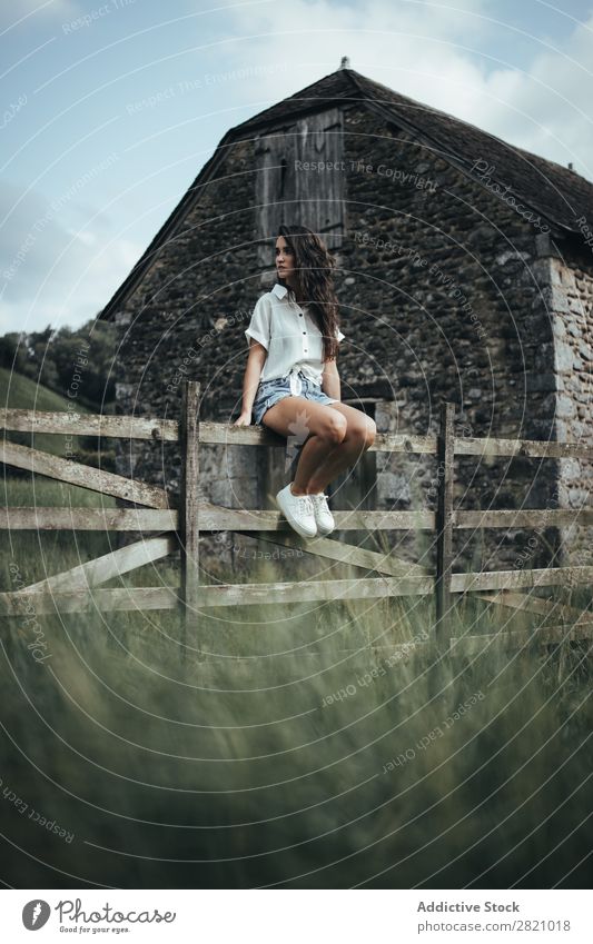 Woman sitting on wooden fence Fence Rural Sit Barn Indicate Wood Nature Landscape Summer Green Beautiful Countries Cute Human being Youth (Young adults) Village