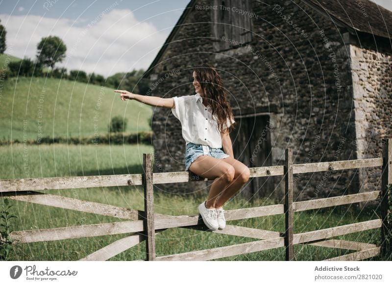 Woman sitting on wooden fence Fence Rural Sit Barn Indicate Wood Nature Landscape Summer Green Beautiful Countries Cute Human being Youth (Young adults) Village