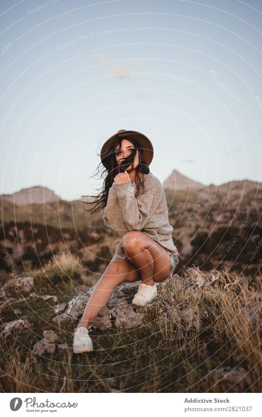 Woman in windy day on rock Rock Sit Mountain Hat Flying Hair Vacation & Travel Top Freedom Youth (Young adults) Nature Tourist Peak Adventure Landscape Action
